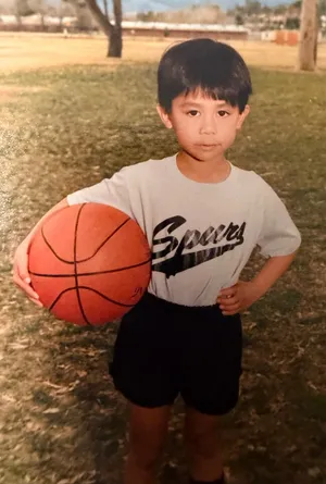 Bobby as a young boy in a Spurs T-shirt, holding a basketball