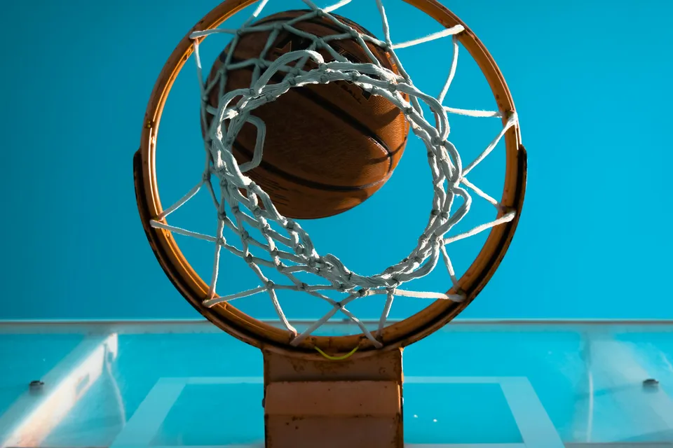 A basketball dropping through the net, seen from below